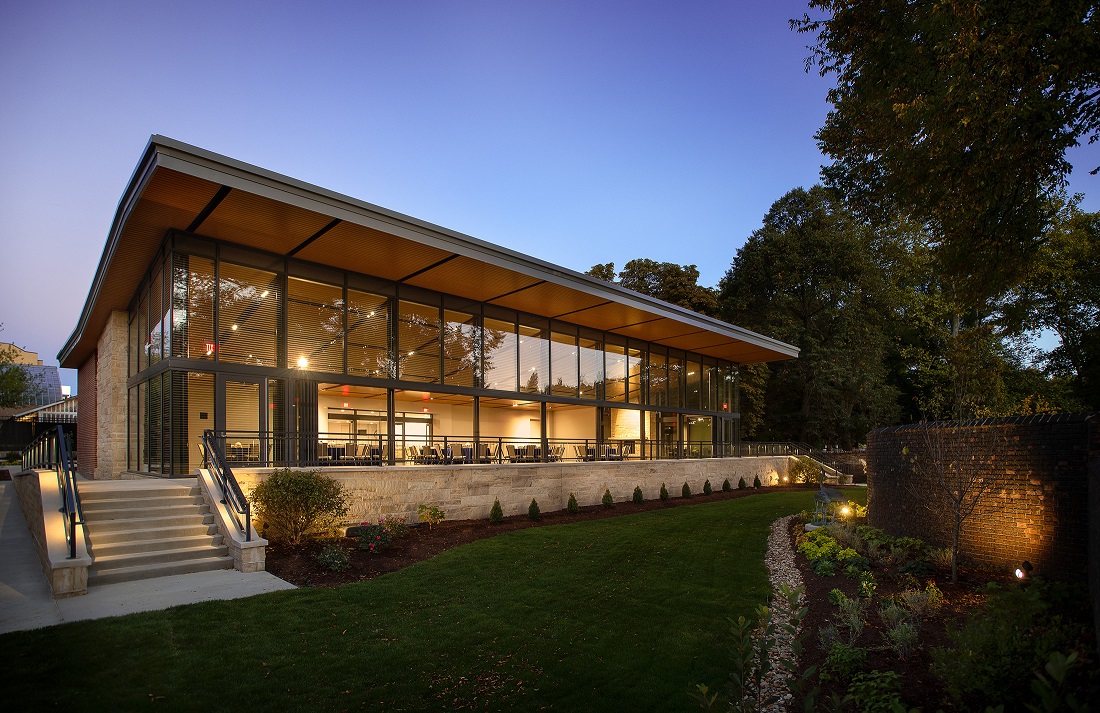 The Garden room exterior with doors open at dusk