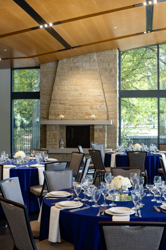 Three round event tables set up for an event in The Garden room with a fireplace