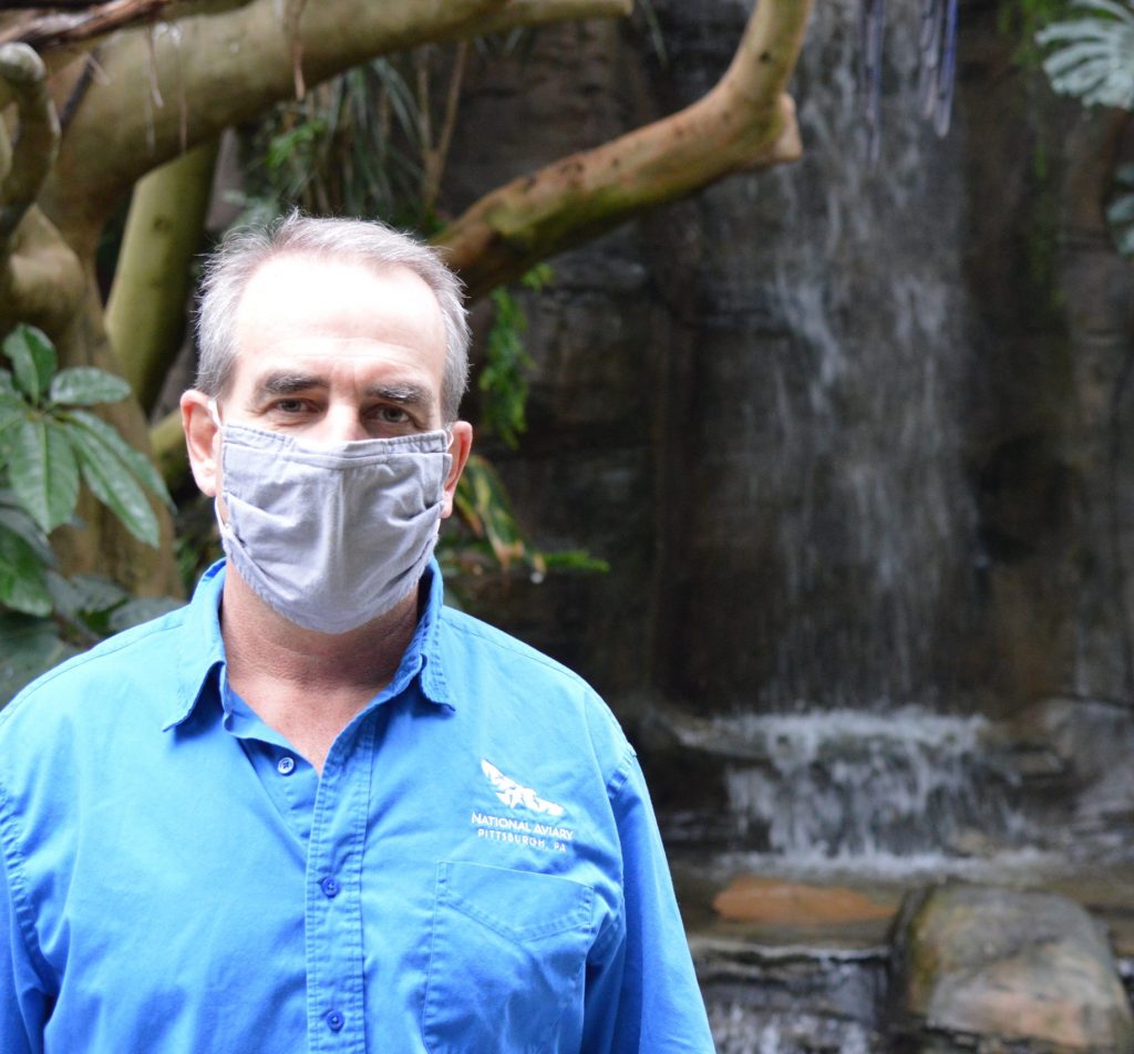 Director of Animal Collections Kurt Hundgen in front of a waterfall