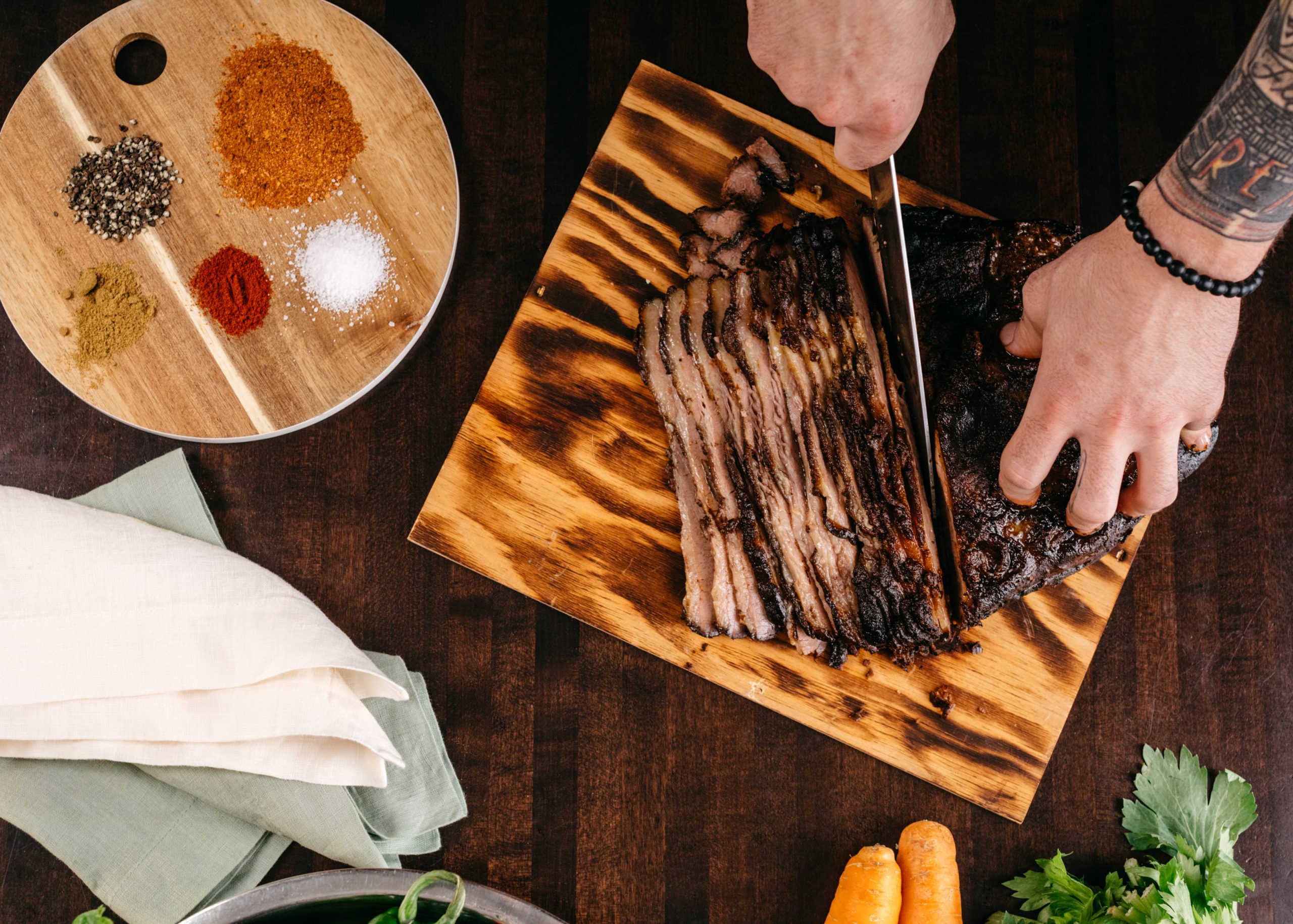 Hands cutting a beef brisket