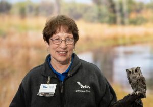 2022 National Aviary Volunteer of the Year Janet Robb holding an Eastern Screech-Owl