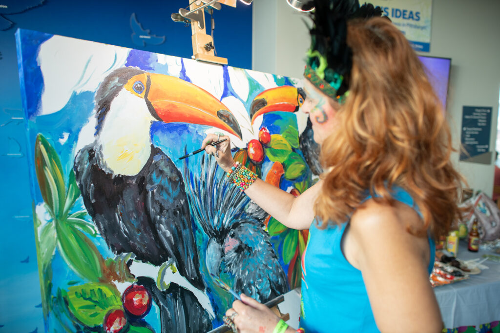 Maria DeSimone Prascak of Maria's Ideas paints a vibrant Toucan during National Aviary's Night in the Tropics.