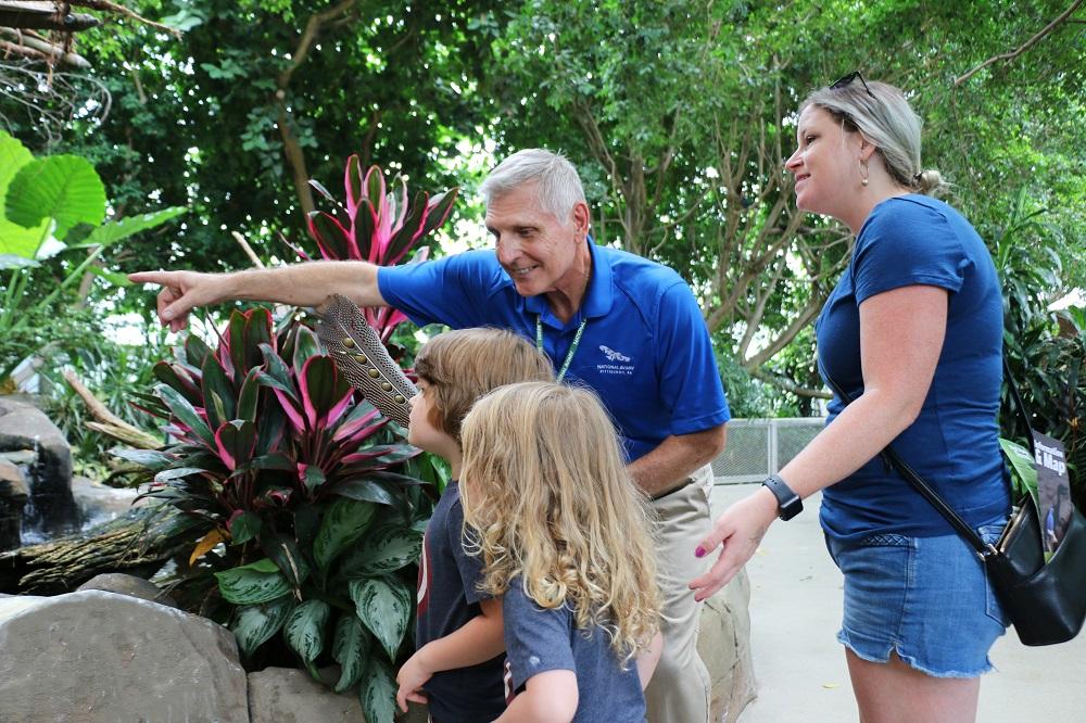 A National Aviary volunteer answers question for an enthusiastic group of children in Tropical Rainforest.