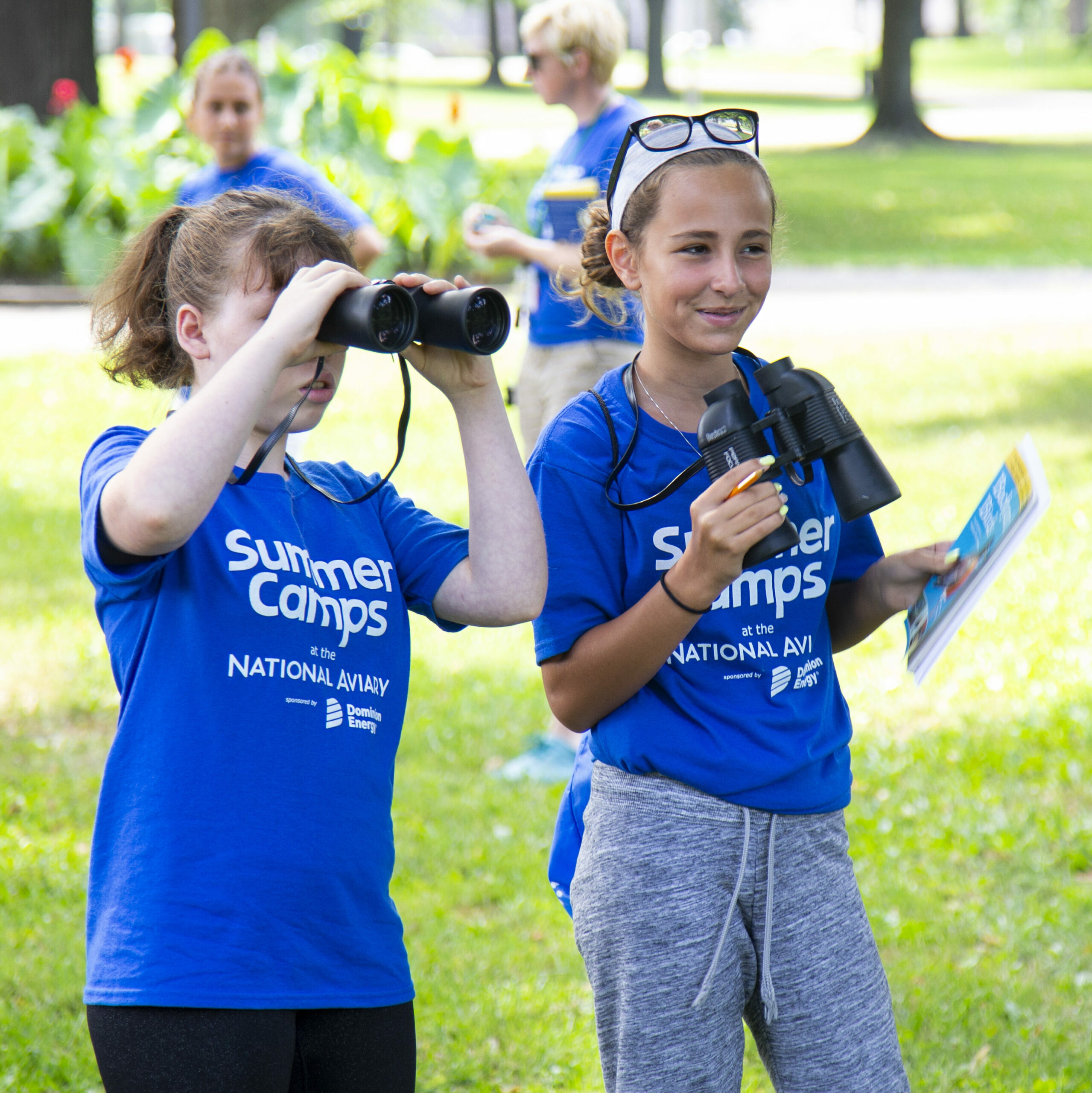 Two teenagers using binoculars at the National Aviary's Summer Camp.