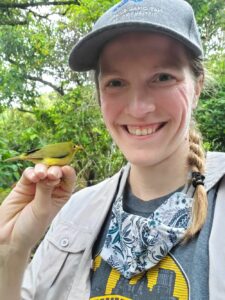 National Aviary Senior Aviculturist, Bri Crane holding a Nosa while in the Mariana Islands with the MAC Project