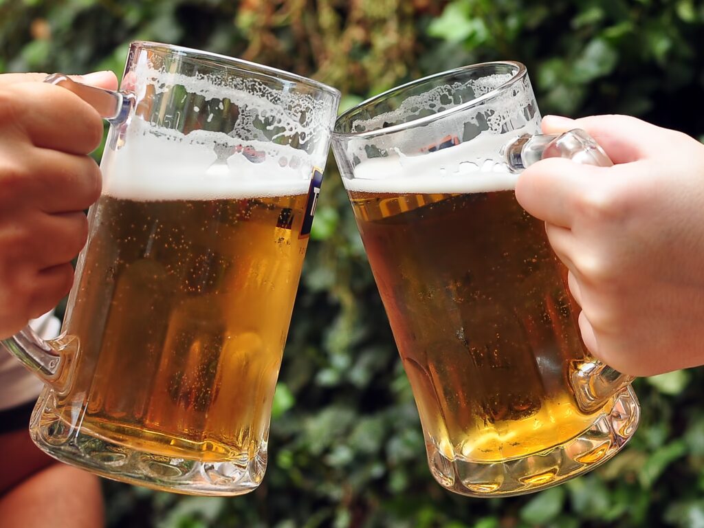Two people clinking beer glasses together
