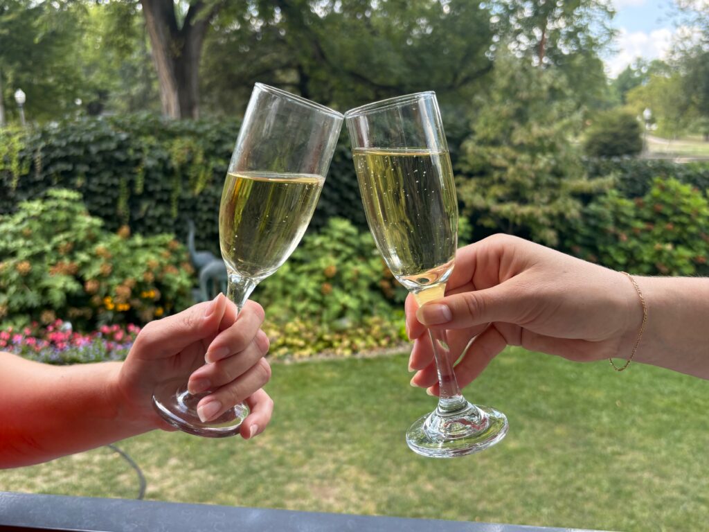 Two friends clinking two classes of champagne together